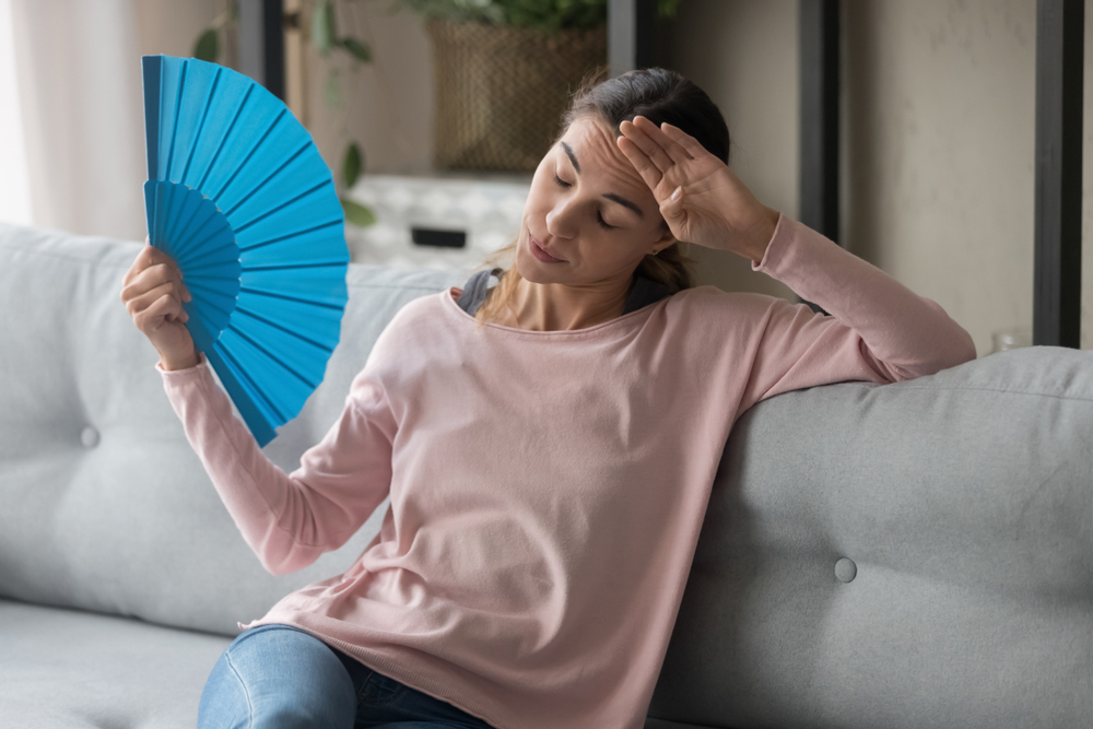person using fan to keep cool