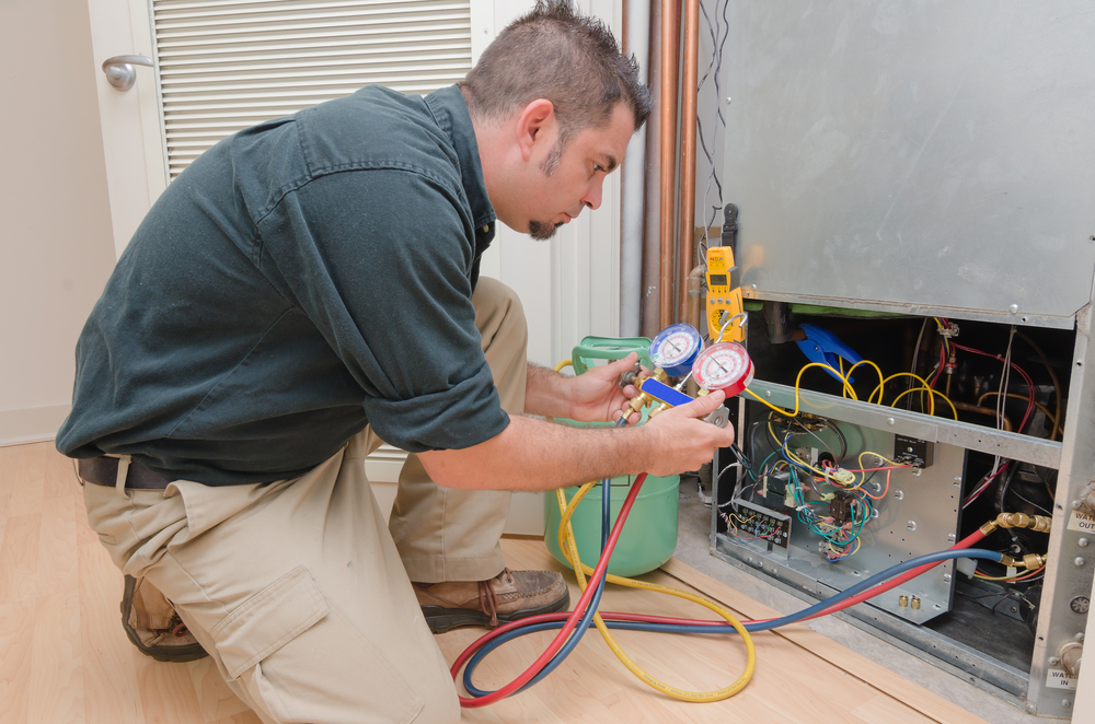 HVAC technician working on a heat pump to check the refrigerant level