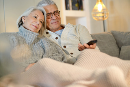 older couple wearing thick sweaters in their livingroom