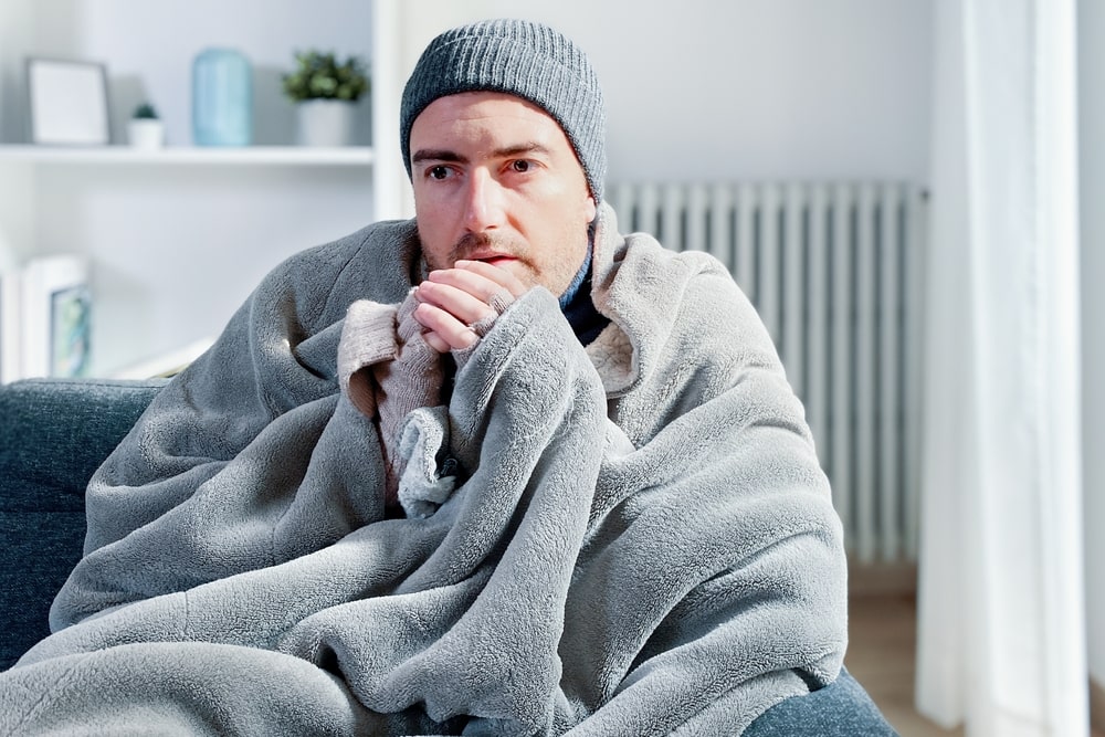 Cold man in blanket needs to fix his furnace