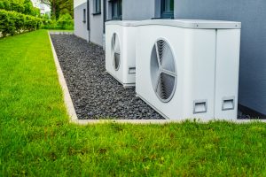 Two air source heat pumps installed outside of new and modern city house, green renewable energy concept of heat pump